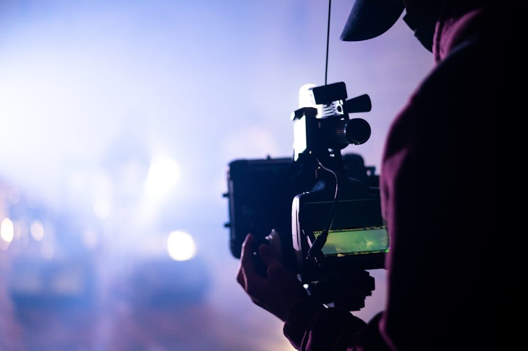 Camera operator filming on a television set with studio lights