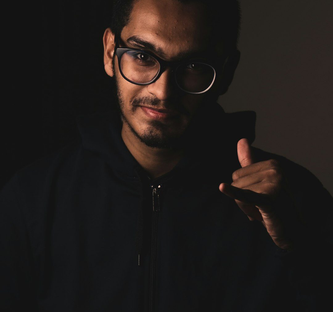 Studio portrait of a man with beard and glasses, camera operator